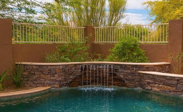 water-feature-at-pool-with-stacked-stone-wall-633x390